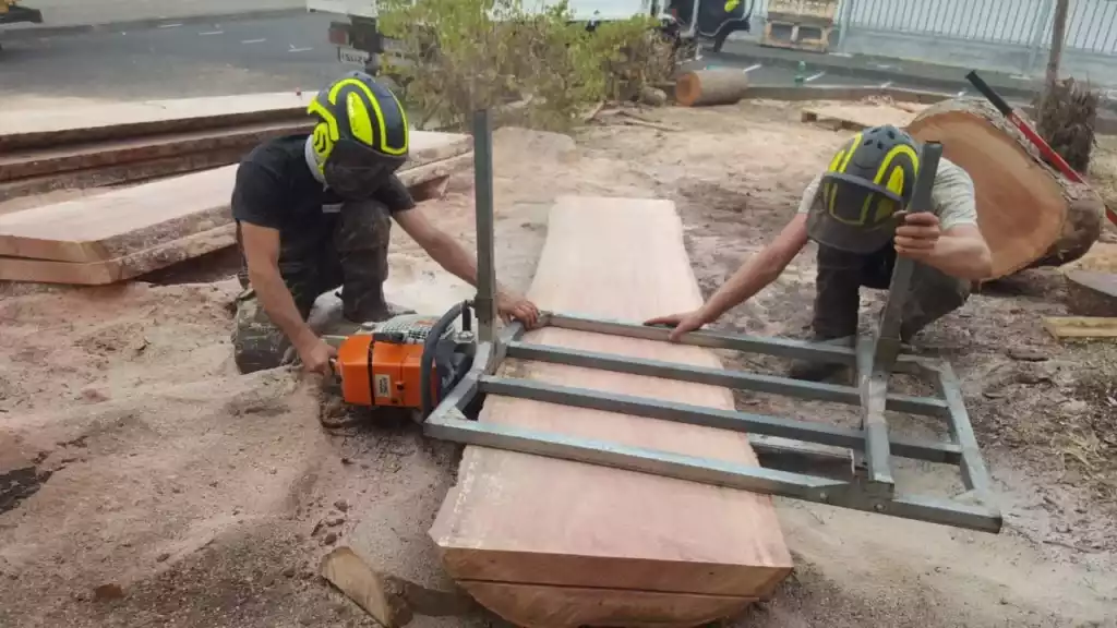 Sciage d'une grume en planches à la scie mobile sur le chantier